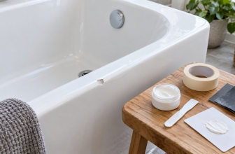 Realistic close-up of a chipped white bath surface with cosmetic repair materials and a small repair area