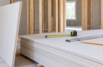 Plasterboard sheets measured with a tape measure and straightedge in a framed room